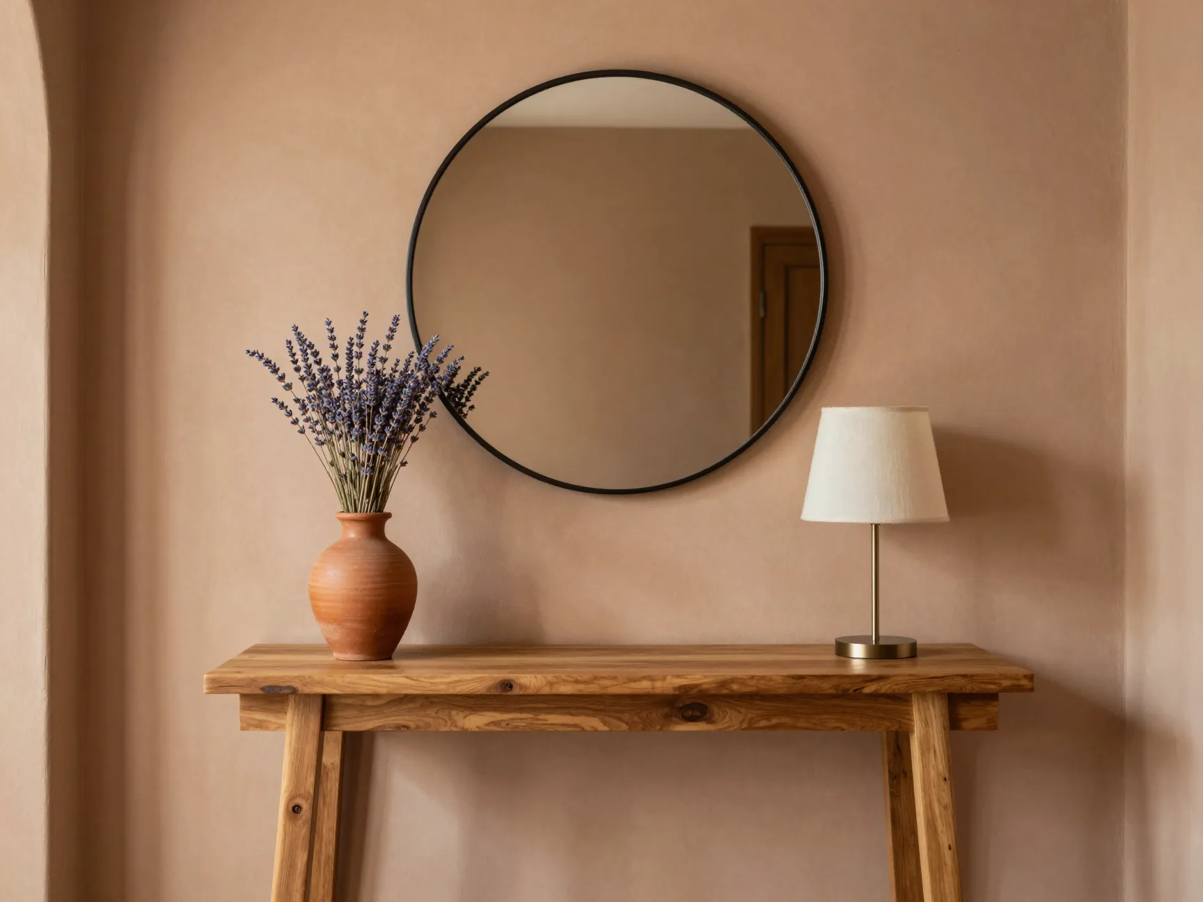 Layer terracotta vases with mirrors and lamps on an entryway console